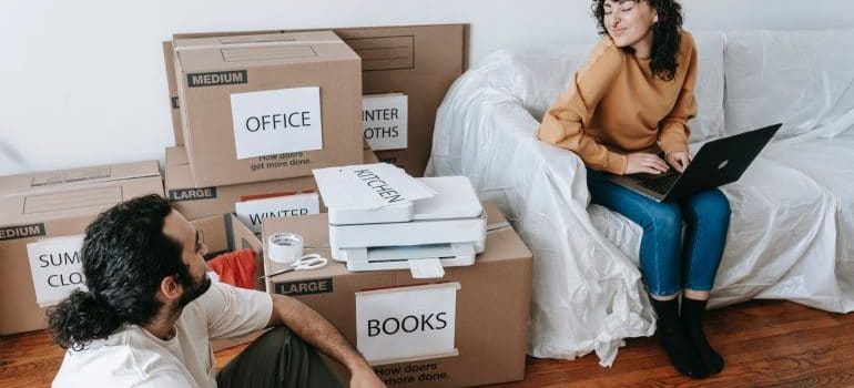 a woman and a man labeling boxes 