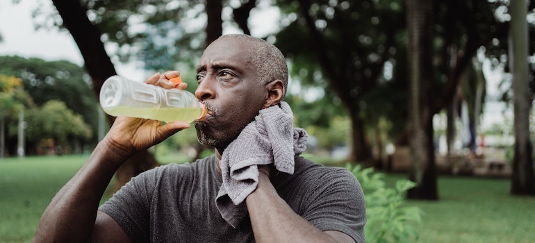 man drinking juice, sweating from high heat