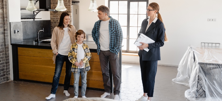 A real estate agent showing a house to a family