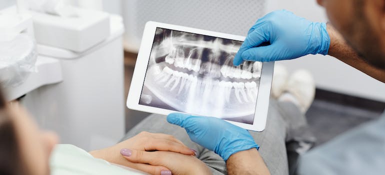 a dentist showing a scan of teeth to his patient