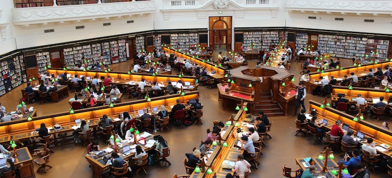 a large university library with lots of students in it