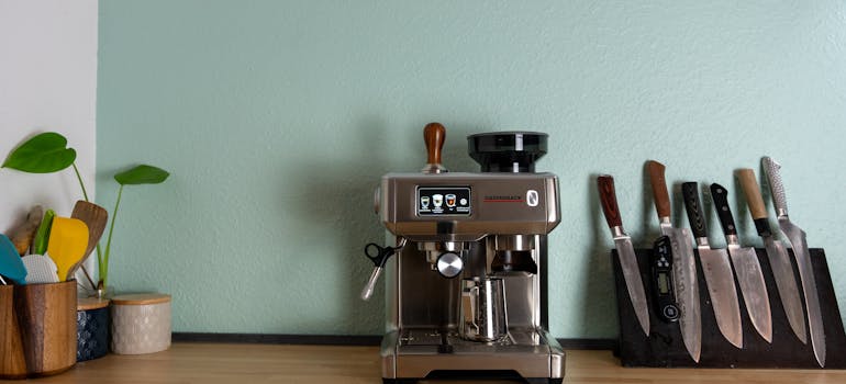 a coffee machine next to a magnetic strip that holds several knives