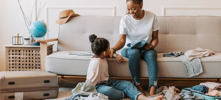 a mother and a daughter evaluating clothes in a living room