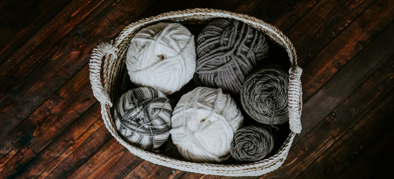 a white basket with yarns in it