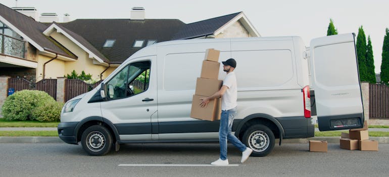 a professional mover in front of the white van that can help you move a large collection to your new Lake Forest home