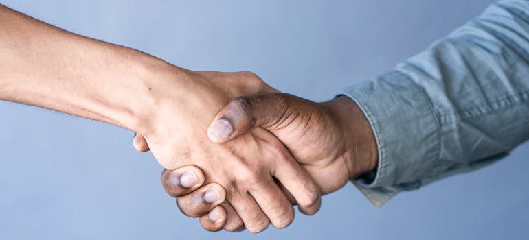 a close-up of two people shaking hands in agreement