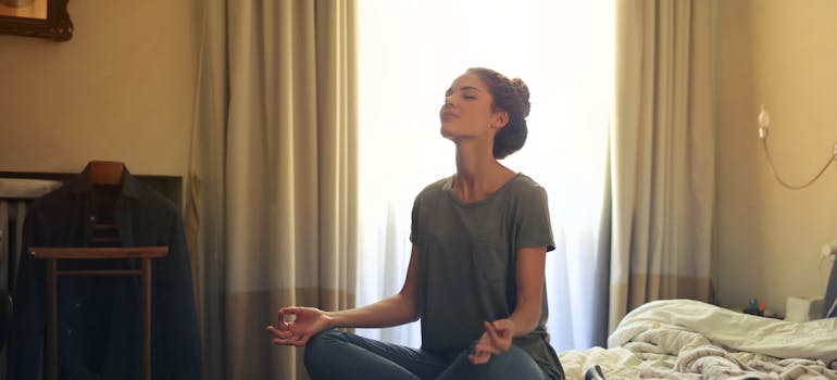 a woman in a meditative position in her bedroom