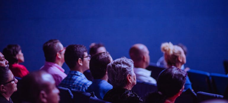 many people in a cinema with blue walls