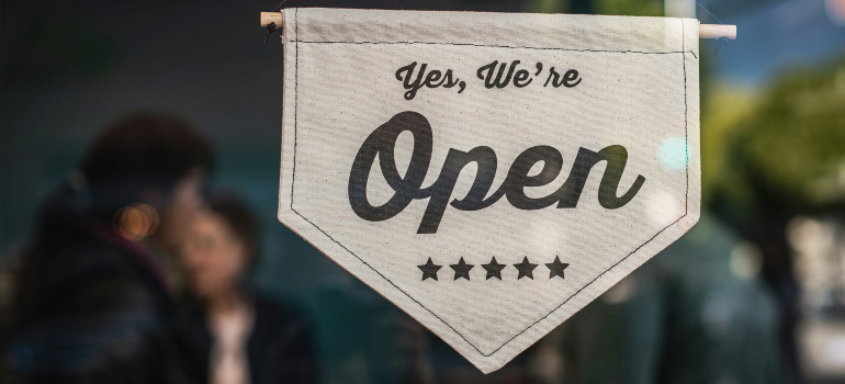 a sign on a bar that says "Yes, We're Open"