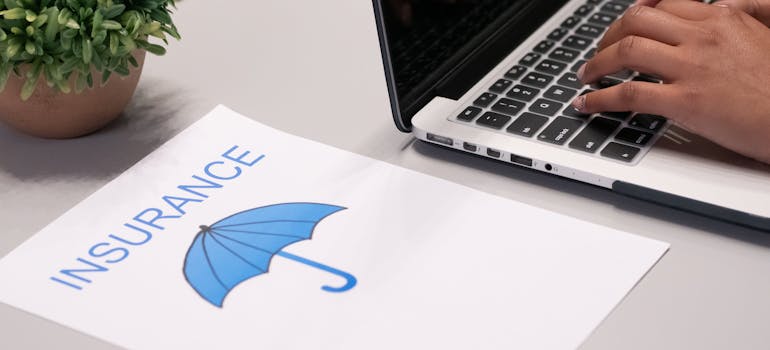 a person working on their computer next to which there's a paper with a blue umbrella on it