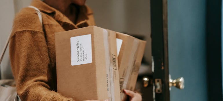 a woman carrying boxes with addresses on them