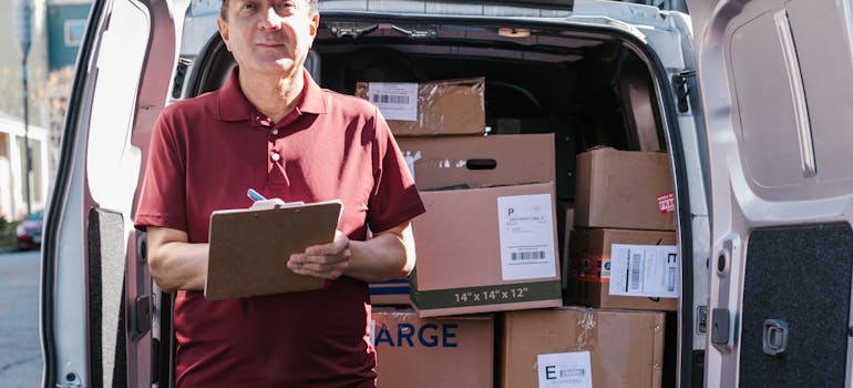 a man standing in front of a van filled with boxes