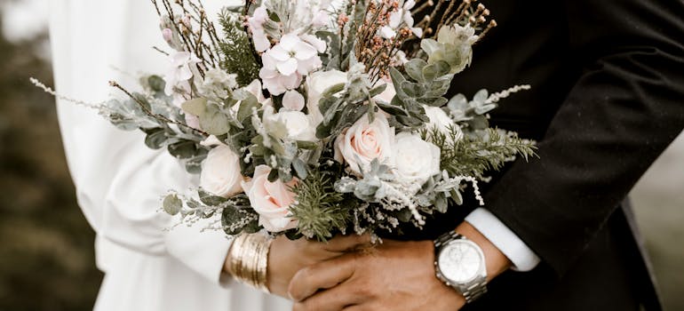 a close-up of a wedding couple holding wedding flowers together