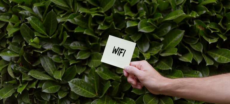 a person holding a card with "WIFI" written on it, indicating another of the common things people forget to do when moving