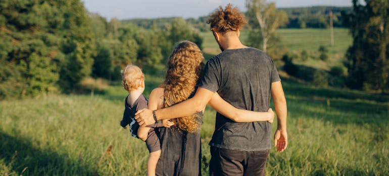 a family of three enjoying a sunny day in a green field