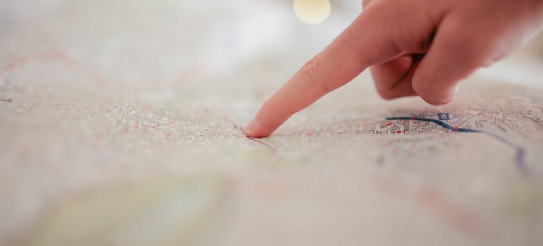 a person pointing with his finger at a spot on a map