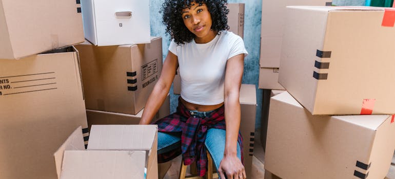 a woman surrounded by boxes, which is great to use when you need to pack kitchen cabinets for the move