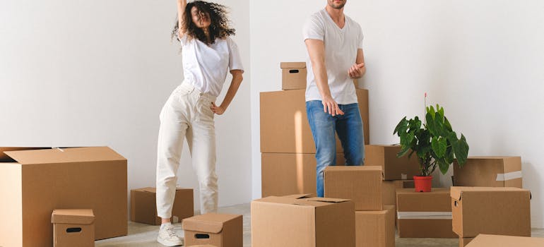 two people who are dancing around cardboard boxes