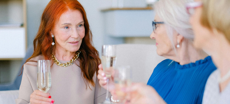 three elegant older ladies having champagne together