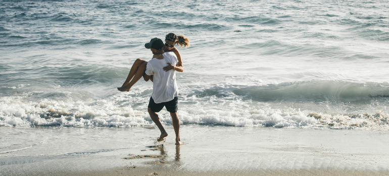 two people having fun at the beach, which your employees will too if you move your business to Orange County