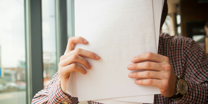 a man holding up some documents he intends to organize, which is one of the common things people forget to do when moving