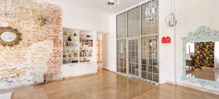 a large living room with huge glass doors and lots of sunlight