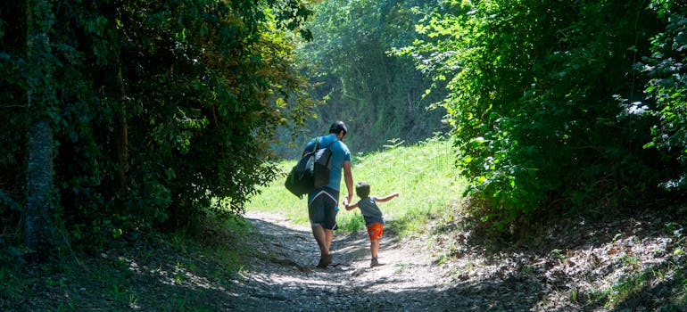 a man and a child hiking along a trail