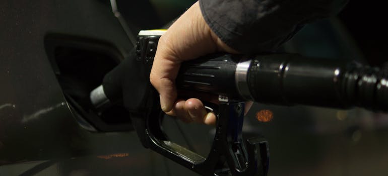 a person filling up a car's tank at a gas station