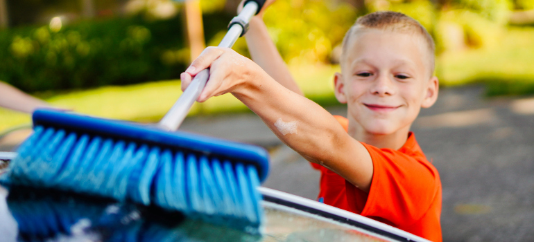 a little boy using a blue cleaning brush