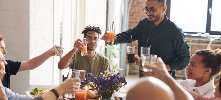 several friends having a casual dinner in a living room belonging to one of them 