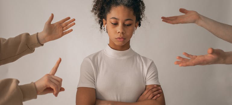 an angry teen and many hands pointing at her