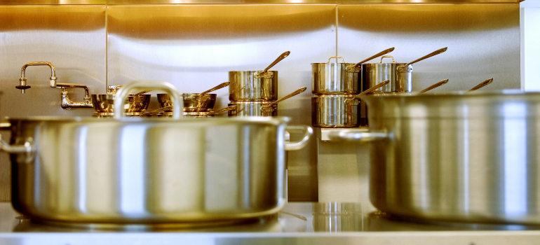 several pots in the kitchen of someone who intends to pack dishes and glasses for moving