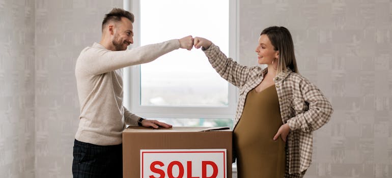 two people celebrating the fact that they have bought a house