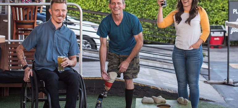 two people with certain disabilities and one girl next to them who is moving with a disabled person to Orange County