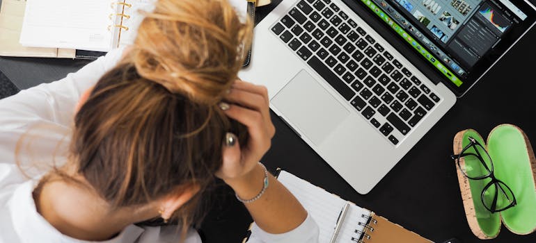 a woman seemingly overwhelmed after working for too long on her computer