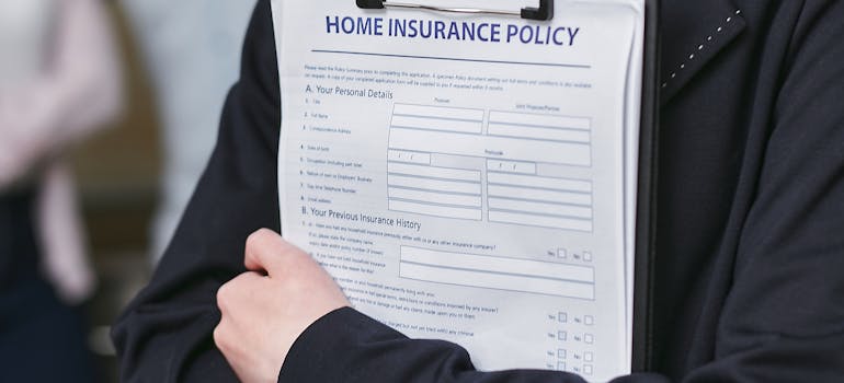 a person holding a form of a home insurance policy