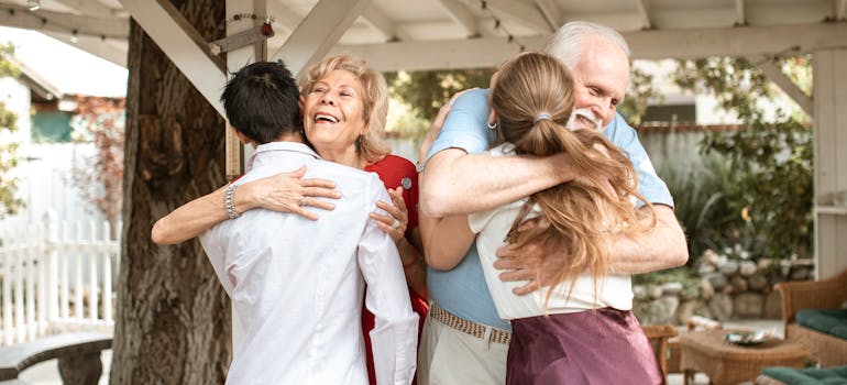 a couple hugging their elderly parents