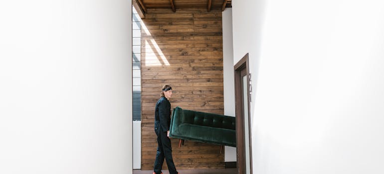 movers carrying a green velvet sofa