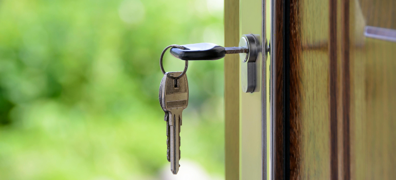 Close-up of house keys in a door lock, symbolizing the appeal of new housing options when Costa Mesa locals decide to move to Santa Ana.