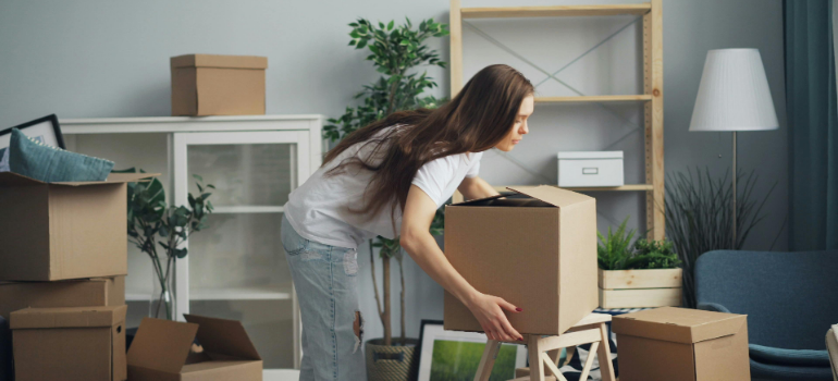 a woman lifting and she knows how to avoid common moving injuries when handling heavy loads