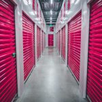 a row of storage units with pink doors