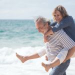 two very happy elderly people enjoying the beach, which is one of the reasons why seniors are moving to Orange County