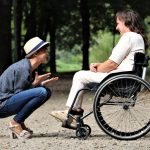 one woman talking to another woman with disabilities