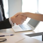 two people shaking hands because one of them managed to find a job after moving to Lake Forest