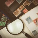 a stamp collection and a magnifying glass next to it