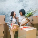 two women holding boxes and talking about the top benefits of hiring local movers