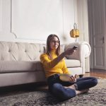 a woman sitting on the floor and wondering what is a good age to start living alone