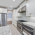 a white kitchen with many cabinets