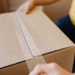 one of the first-time renters in Newport Beach CA sealing a cardboard box