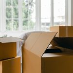 several cardboard boxes next to a window in a house